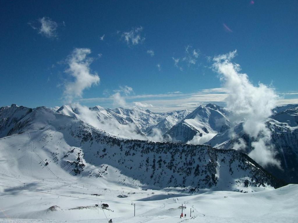 una vista de una montaña nevada con gente esquiando en Appartement Pieds des Pistes en Saint-Lary-Soulan