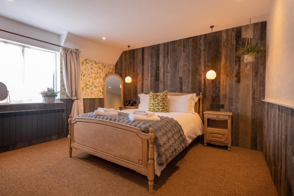 a bedroom with a large bed and a mirror at The Wishful Thinker in Kent