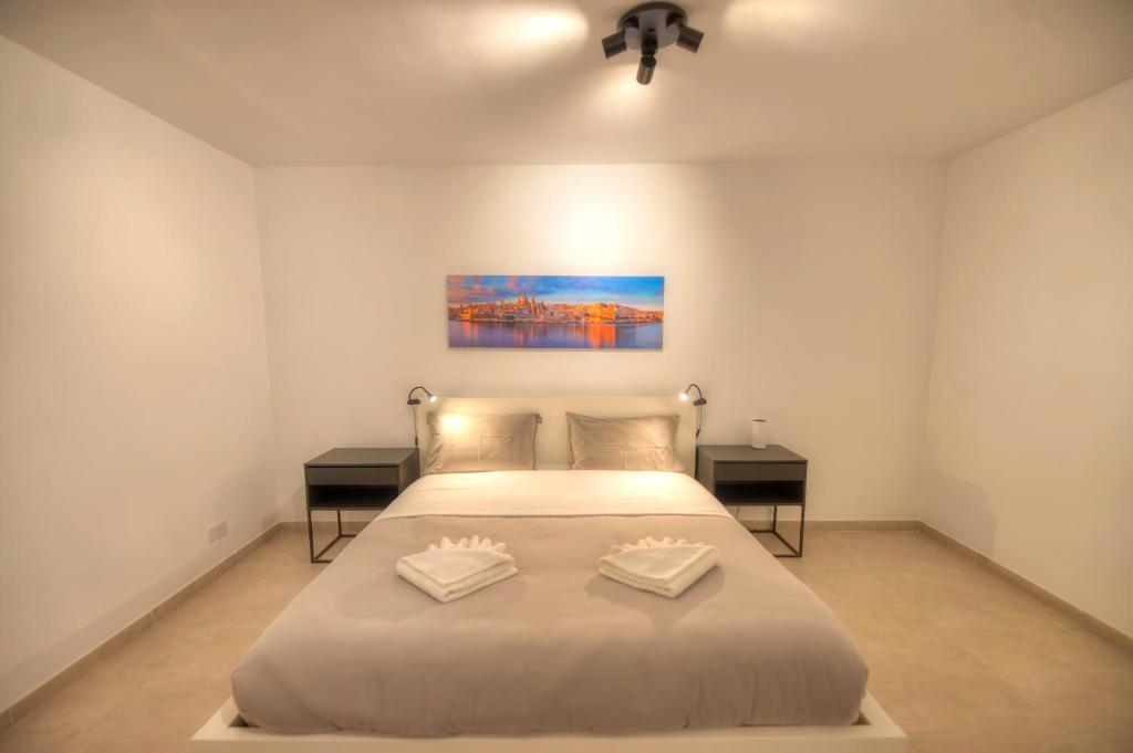 ein Schlafzimmer mit einem großen Bett mit zwei Tischen in der Unterkunft Spacious & Tastefully furnished 3 bedrooms RCUT1-1 in Is-Swieqi