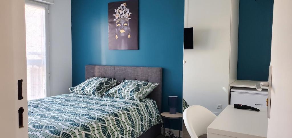 um quarto com paredes azuis e uma cama com lençóis azuis em Charming Room with shared space close to PARIS - Chambres Confort avec espaces partagés proche de PARIS em Vitry-sur-Seine