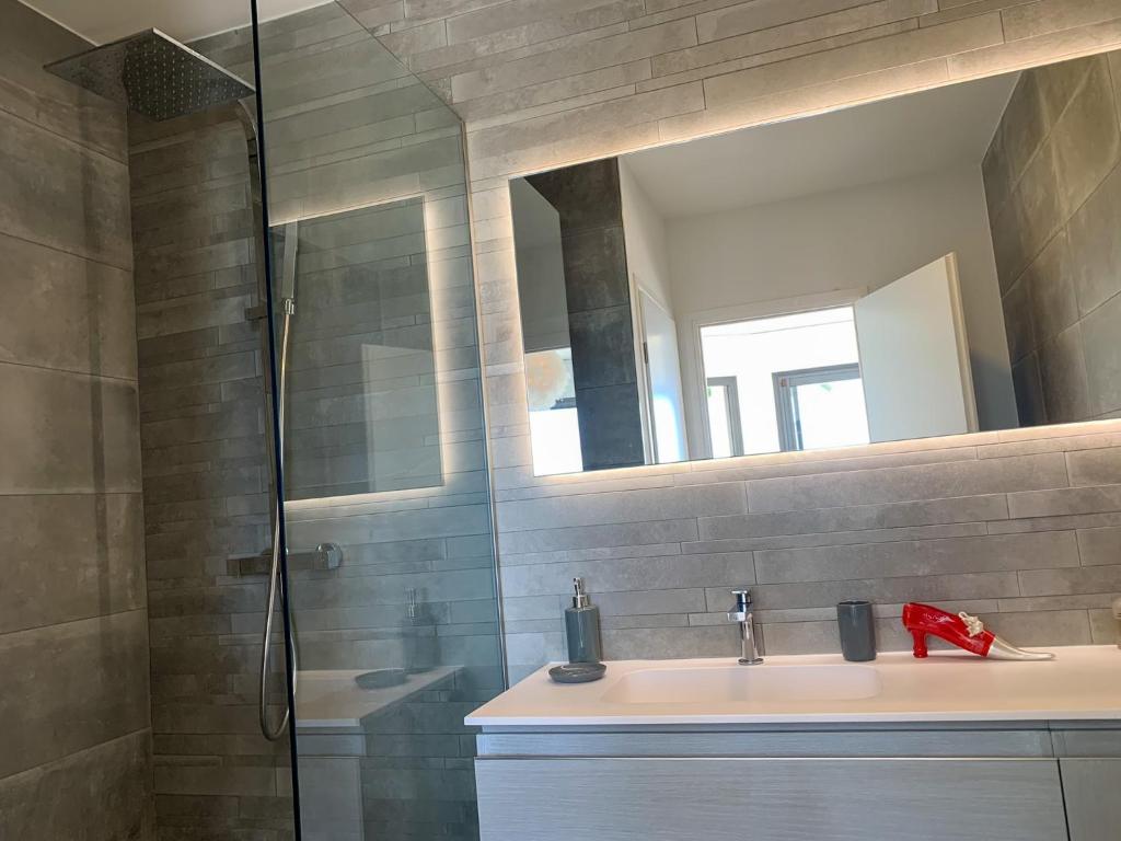 a bathroom with a sink and a shower with a mirror at Séjour de Luxe à Golfe Juan, 15 mn de Cannes in Vallauris