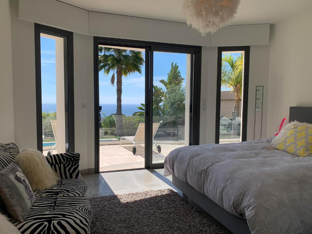 a bedroom with a bed and a large glass window at Séjour de Luxe à Golfe Juan, 15 mn de Cannes in Vallauris