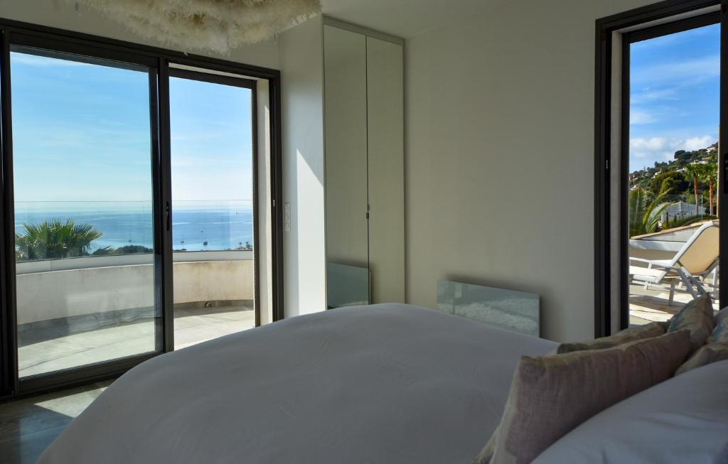 a bedroom with a bed and a view of the ocean at Séjour de Luxe à Golfe Juan, 15 mn de Cannes in Vallauris