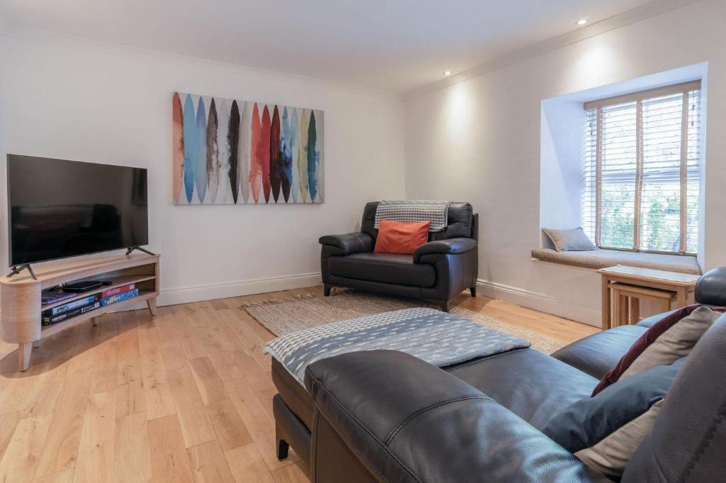 a living room with a couch and a tv at Flat 2 - 2 Bedroom Apartment - Tenby in Tenby