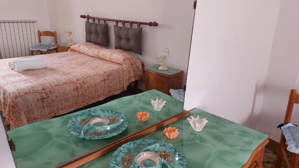 een slaapkamer met een bed en twee tafels met borden erop bij JONIA Appartamento vacanze vicino al mare con giardino in Pulsano