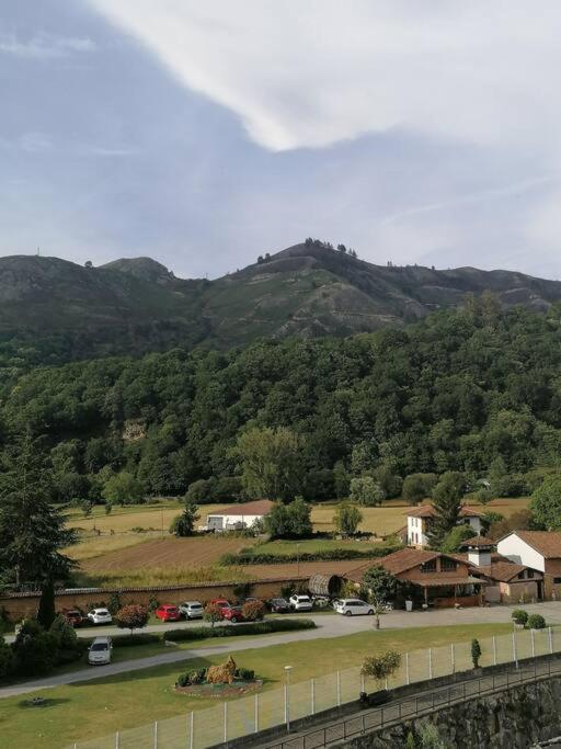 a view of a town with mountains in the background at Ático 3 hab en centro de Cangas in Cangas de Onís