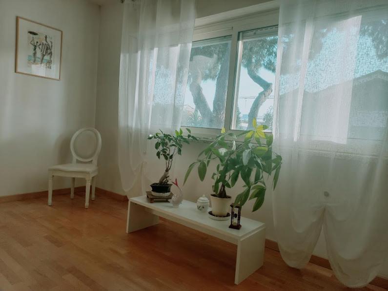 a room with a window with plants and a table at A un passo da... B&B in Elmas