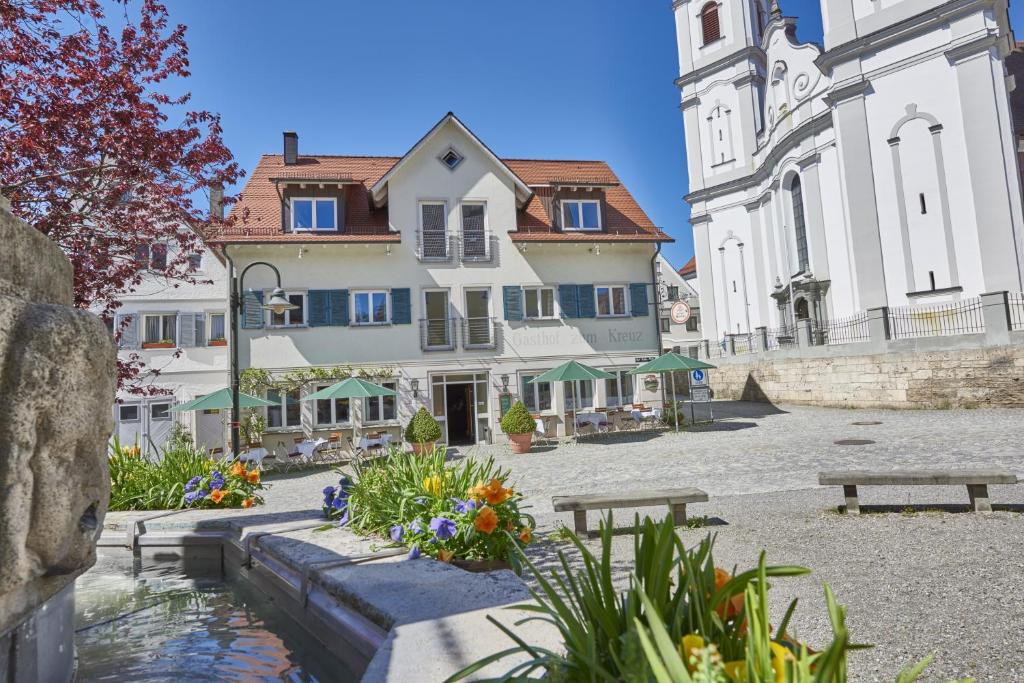 eine Gruppe von Gebäuden mit einem Teich im Innenhof in der Unterkunft Gasthof Kreuz in Bad Waldsee