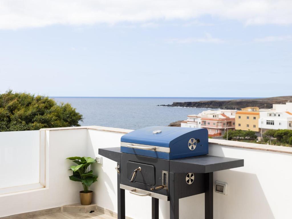 a blue gas grill on a balcony with a view of the ocean at Live Arico Burgado in Arico