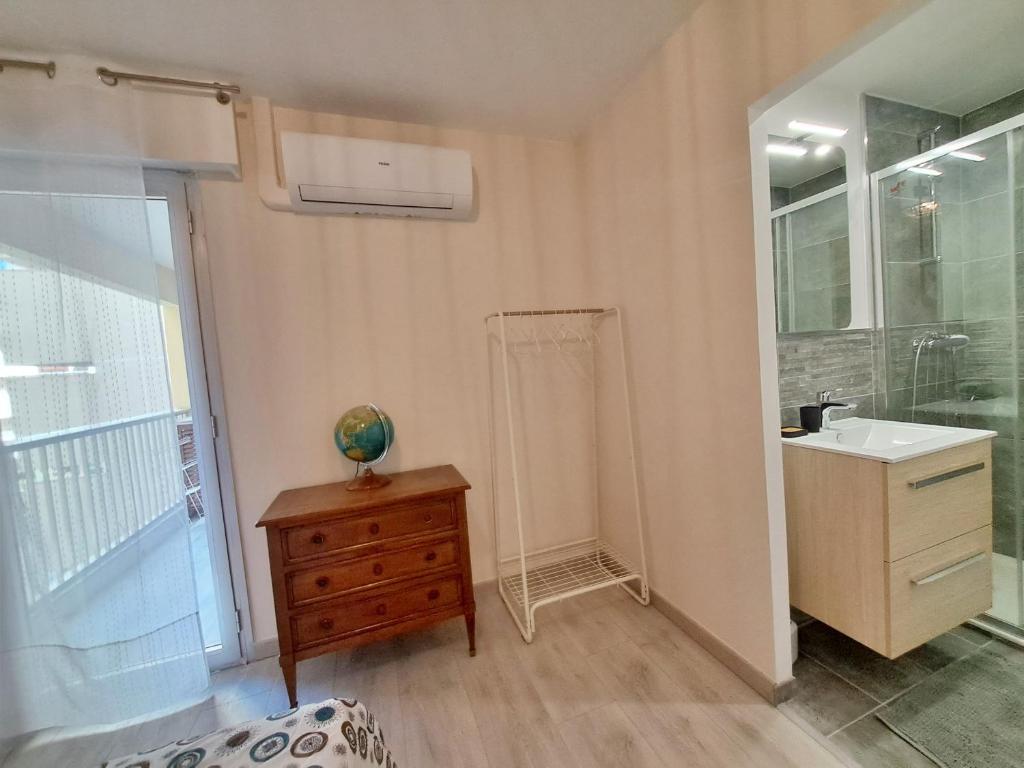 a bathroom with a sink and a mirror and a dresser at Saint-Raphaël-Front de Mer-WIFI-CLIM in Saint-Raphaël