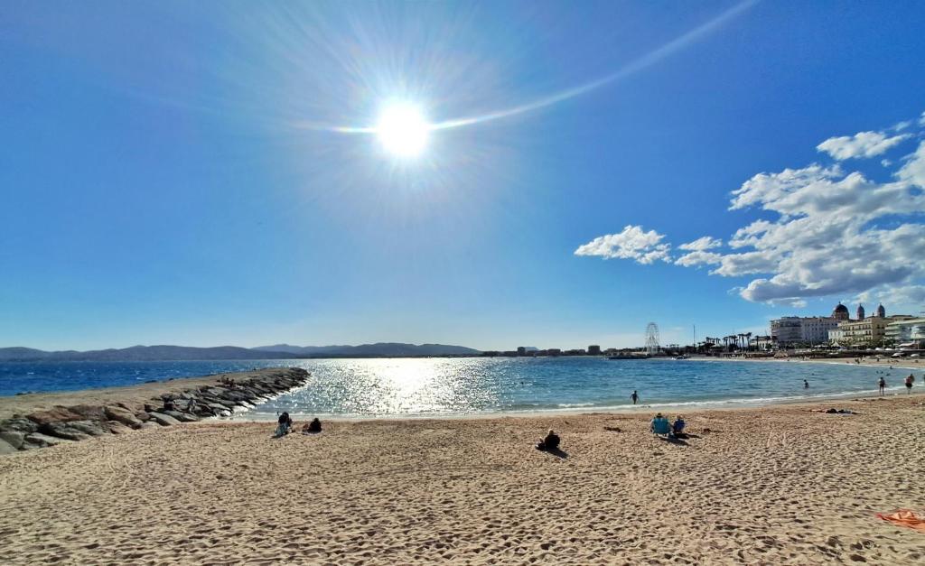 a group of people sitting on a beach at Saint-Raphaël-Front de Mer-WIFI-CLIM in Saint-Raphaël