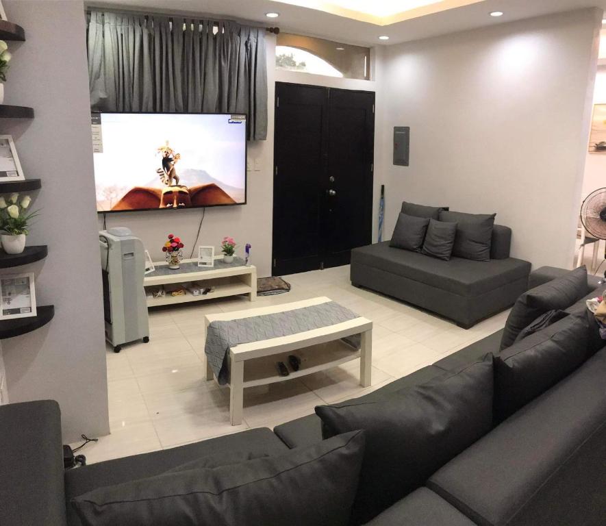 sala de estar con sofá y TV de pantalla plana en CCJ Villa en Bacólod