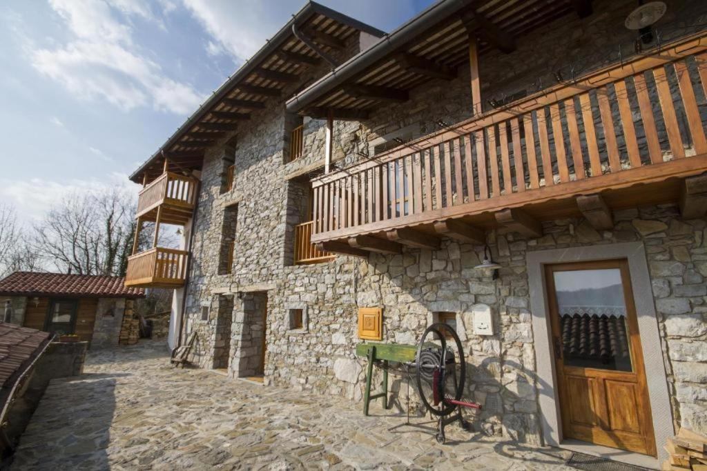 een stenen gebouw met een balkon aan de zijkant bij Casa Ursic Castello in Oblizza