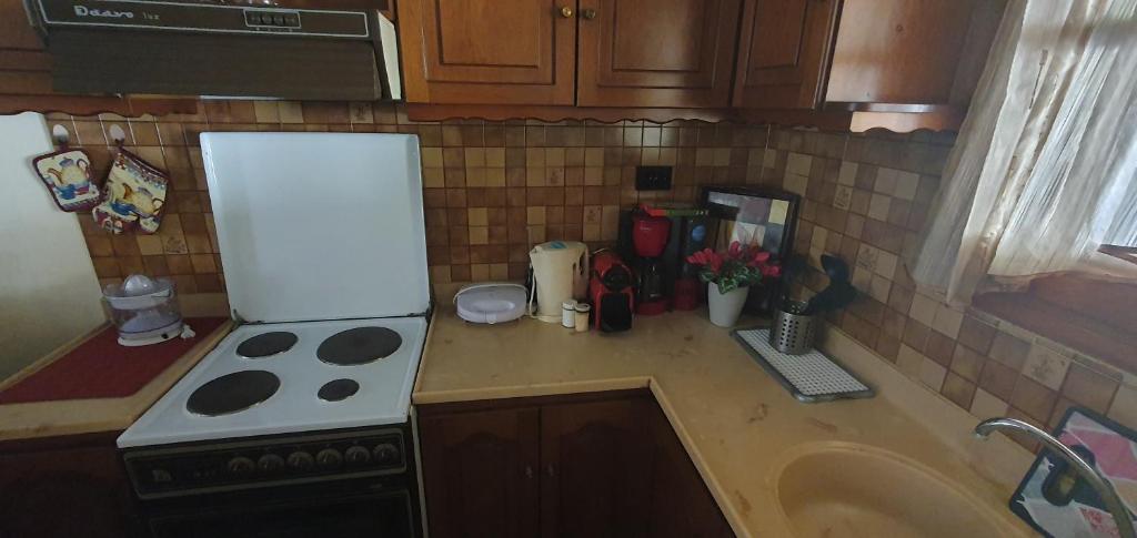 a kitchen counter with a stove and a refrigerator at Adorable 2 floors two bedroom vacation maisonette in Nea Potidaea