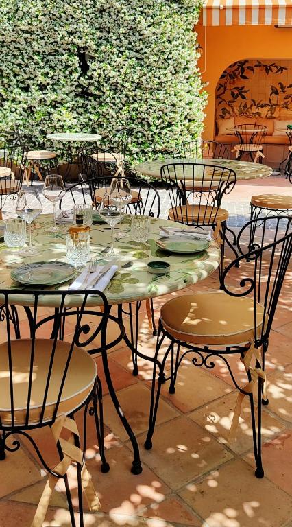 a table and chairs with plates and glasses on it at Hôtel La Pérouse Nice Baie des Anges in Nice