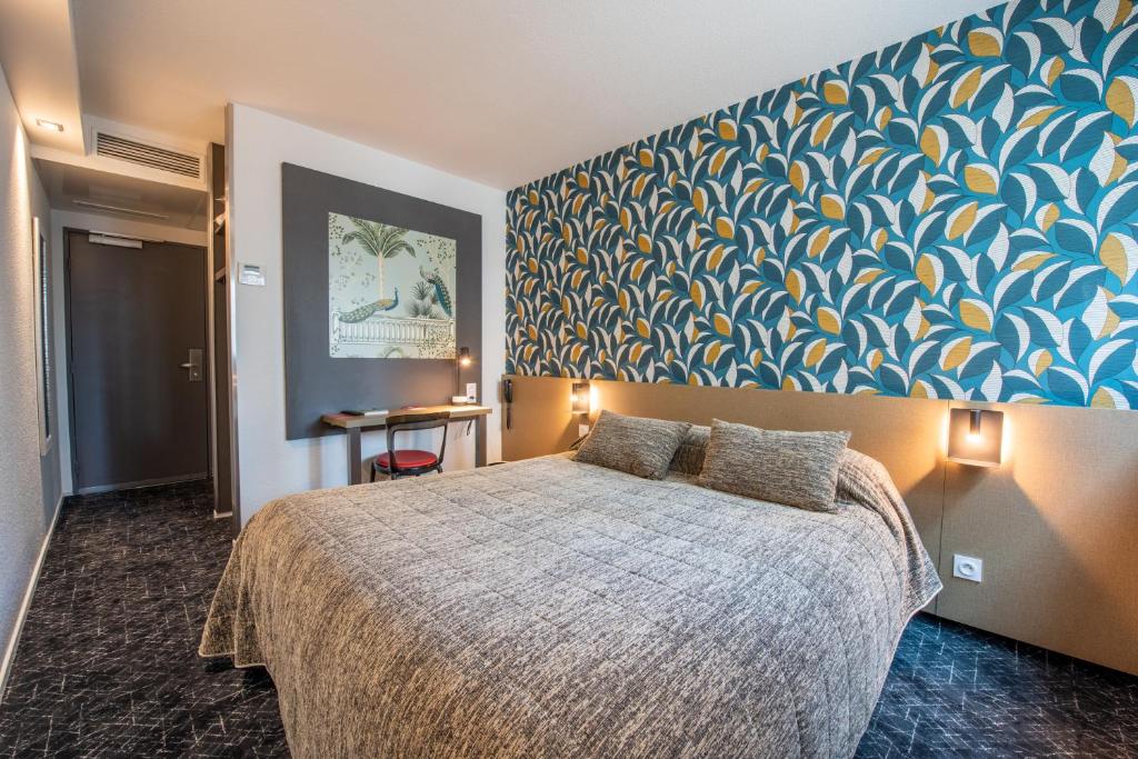 een slaapkamer met een bed met een blauwe en gele muur bij Cit'Hotel Stim'Otel in Agen