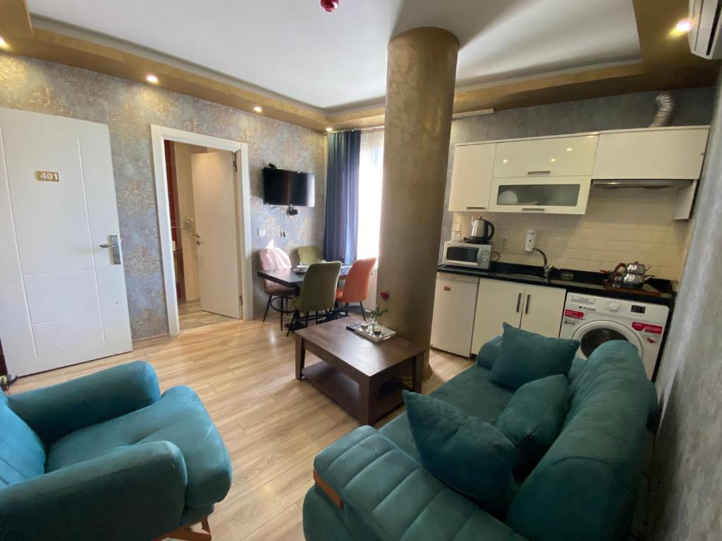 a living room with two blue couches and a kitchen at DVHOTEL in Istanbul