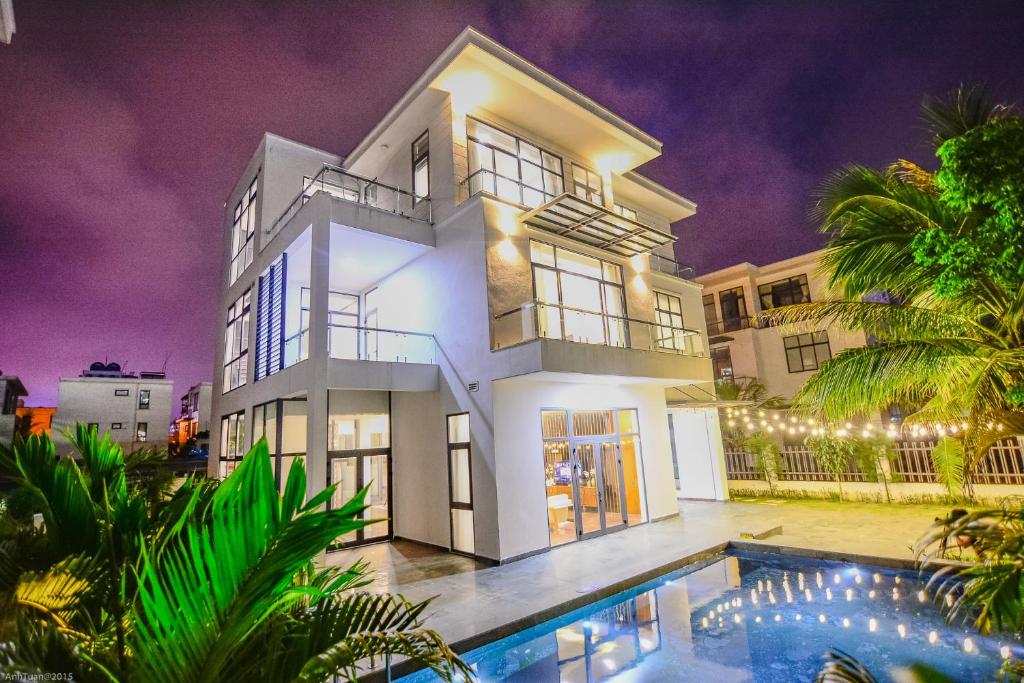 a house with a swimming pool in front of it at FLC Grand Villa BT33-04 in Sầm Sơn