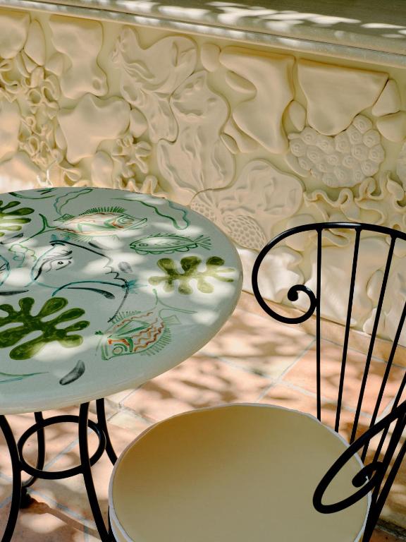 a table and two chairs next to a table and a plate at Hôtel La Pérouse Nice Baie des Anges in Nice