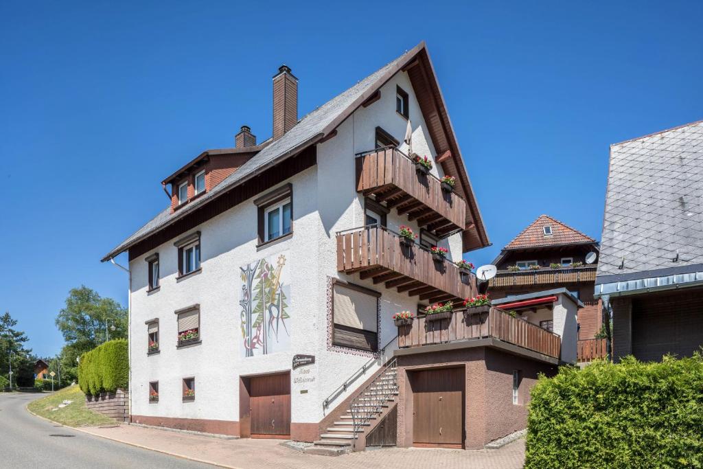 a white building with wooden balconies on a street at Waldesruh in Titisee-Neustadt