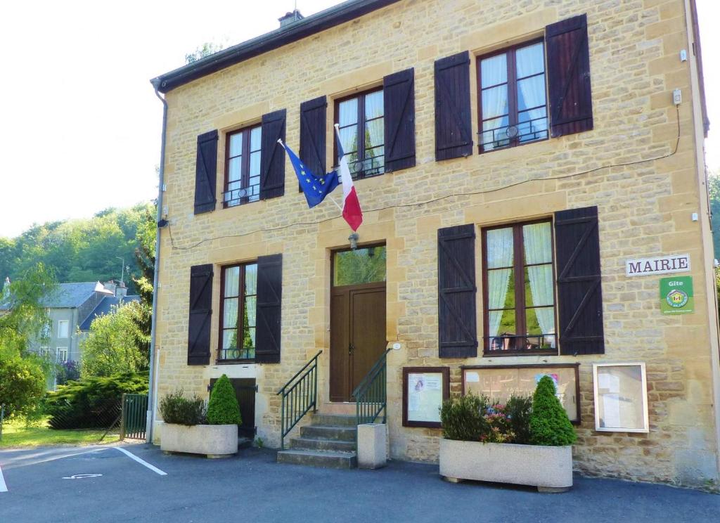 a brick building with a brown door and windows at Gite de l'ecole in Rubécourt-et-Lamécourt