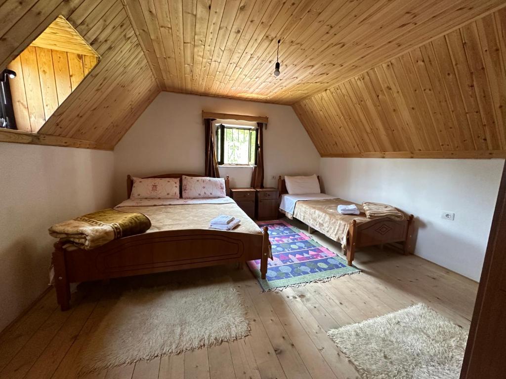 a attic room with two beds and a window at Guesthouse Freskia in Theth