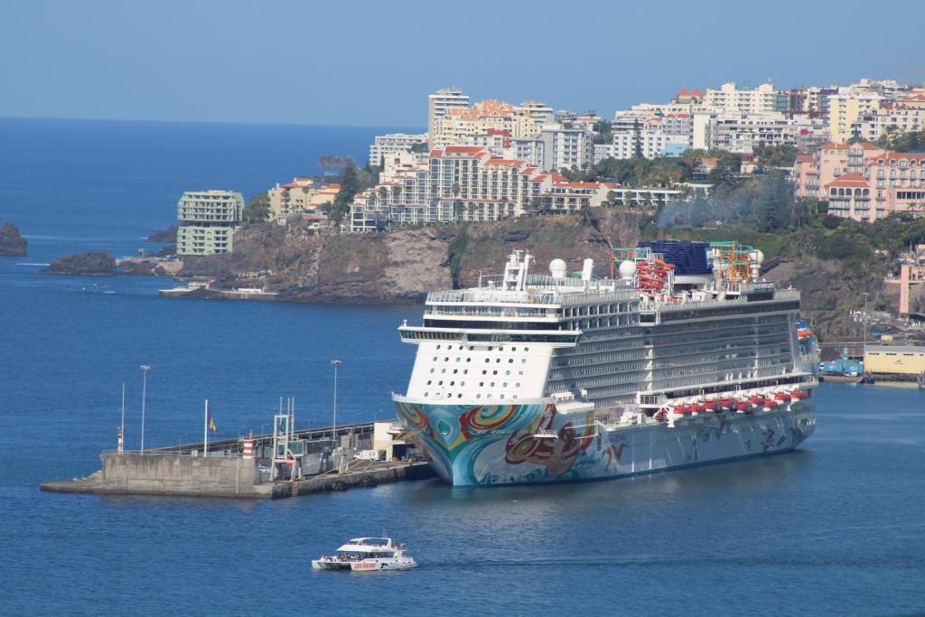 una nave da crociera attraccata in un porto con una città di Sea Front House a Funchal
