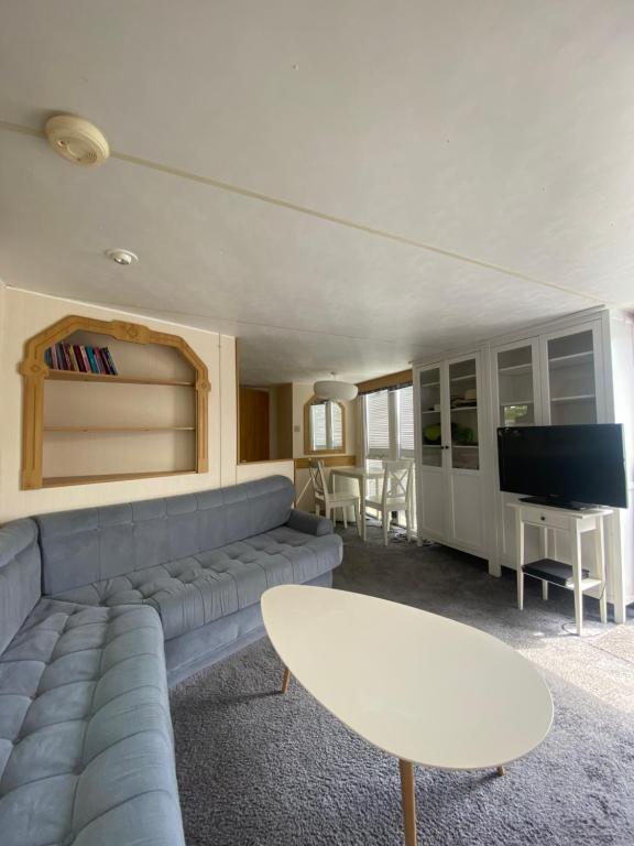 - un salon avec un canapé, une table et une télévision dans l'établissement Dulczetto Camp, à Jastarnia