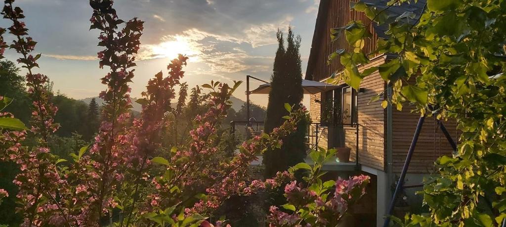 einen Garten mit rosa Blumen vor einem Haus in der Unterkunft Bauernhof Kure in Leutschach