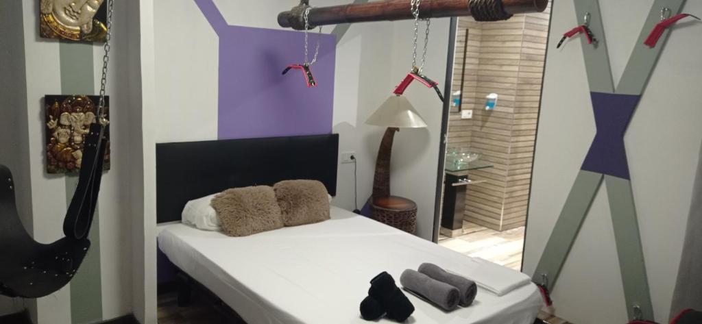 a bedroom with a white bed and a room with paintings at Eternity Alicante in Alicante