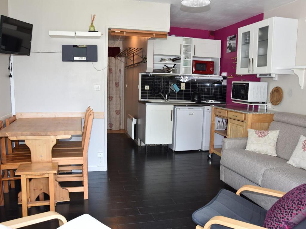 une cuisine et un salon avec une table et un canapé dans l'établissement Studio Sud avec Terrasse, Proche Centre et Téléphérique - FR-1-464-216, à Pralognan-la-Vanoise