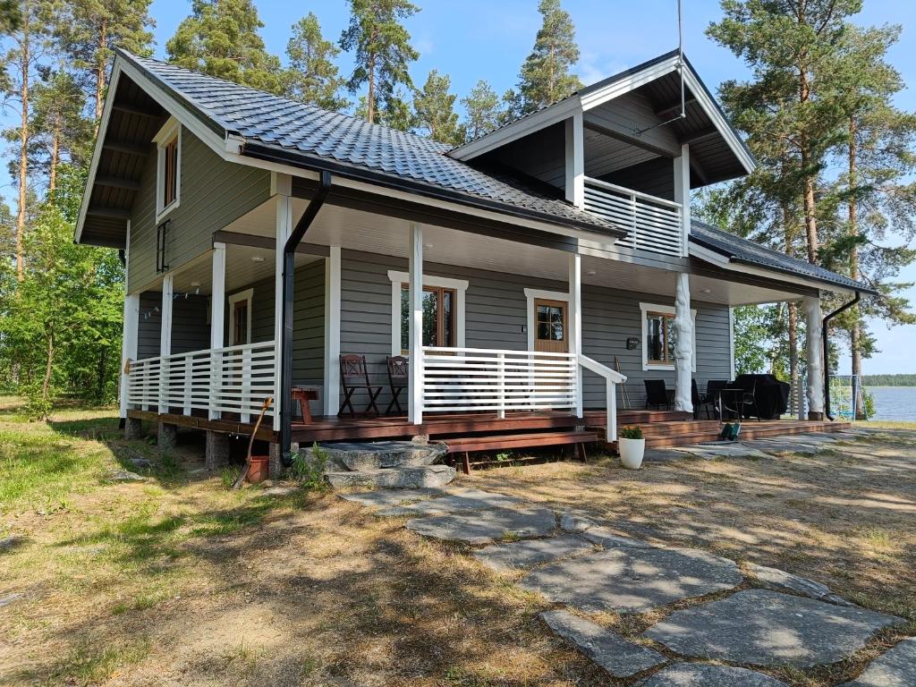 une maison avec une grande terrasse couverte à l'avant et un toit dans l'établissement Topin Tupa 1, à Oravisalo