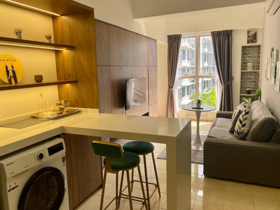 uma cozinha e sala de estar com um balcão e uma máquina de lavar louça em Cosy 2 Bedder Near KLCC I 500mbps Wi-Fi I Smart TV with Netflix Function em Kuala Lumpur