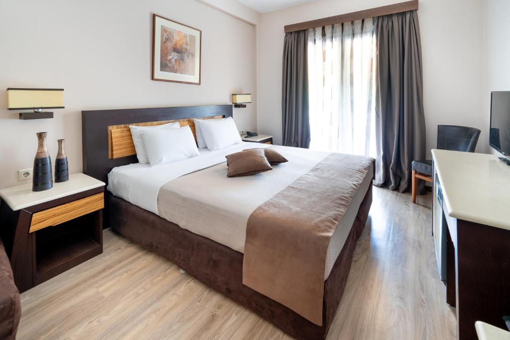Habitación de hotel con cama grande y ventana en Byzantio Hotel, en Tesalónica