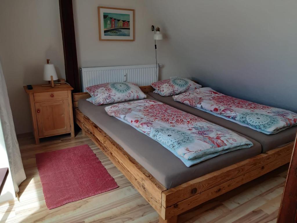 two twin beds in a room with a red rug at Giebelzimmer mit Weinbergblick in Stetten