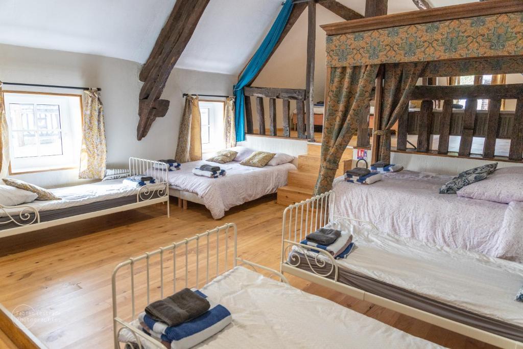 a large room with two beds and two windows at Le Domaine de la Désirée in Lisieux