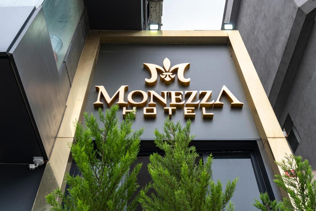 um sinal para um hotel monograma na lateral de um edifício em MONEZZA APART em Avcılar