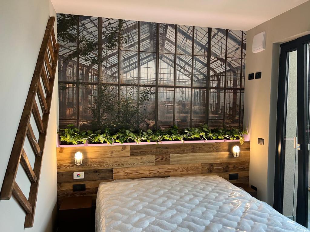 una camera con letto e finestra con piante di Garden Inn - Riva del Garda a Riva del Garda