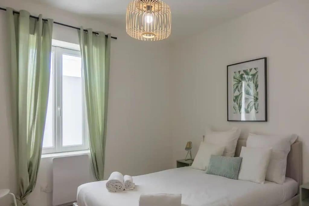 - une chambre avec un lit blanc et une fenêtre dans l'établissement Charme de Loire à St Ay *T2*, à Saint-Ay