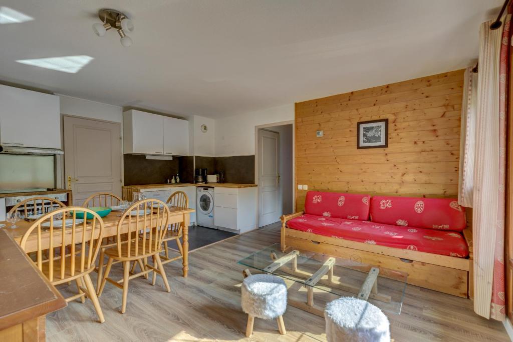 uma sala de estar com um sofá vermelho e uma mesa em Le Goléron des Evettes em Flumet