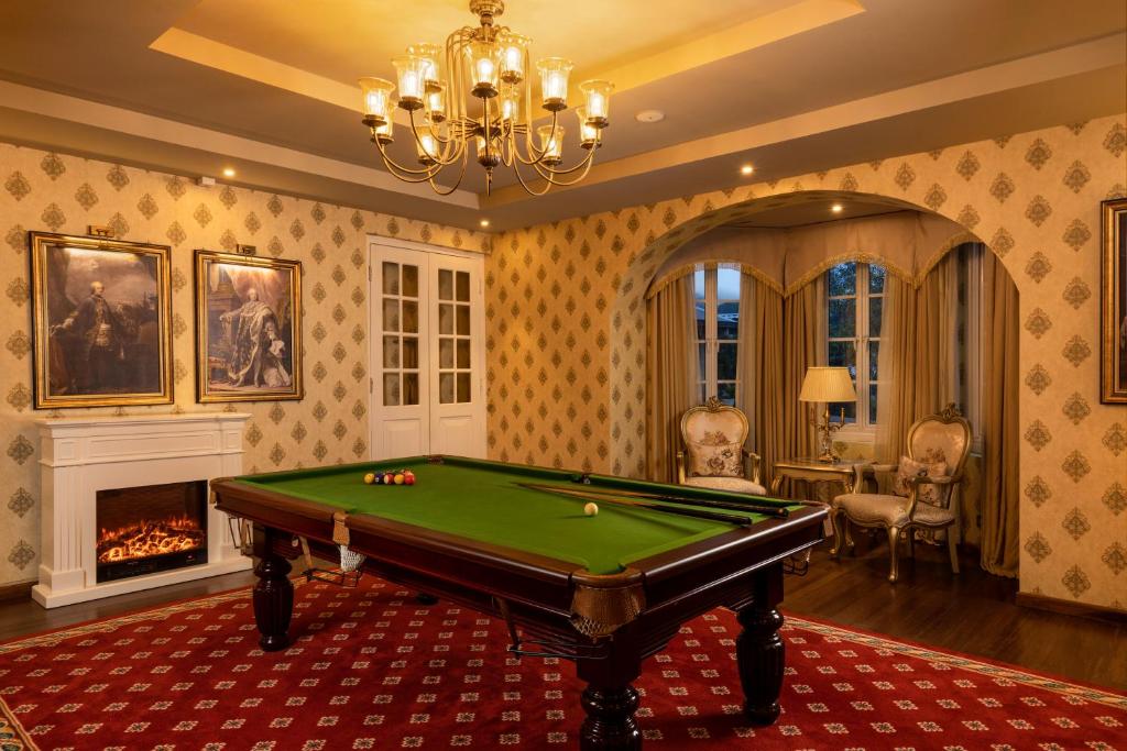 a living room with a pool table and a chandelier at The Westbury Palace in Nuwara Eliya