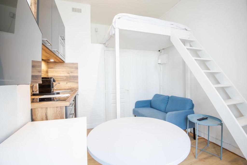 une chambre avec un lit, une chaise bleue et une échelle dans l'établissement Little Victor Hugo, à Tours