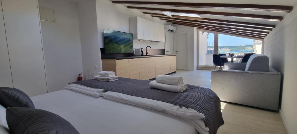 una camera da letto con un grande letto con asciugamani di Dea Del Mar Apartments a Izola