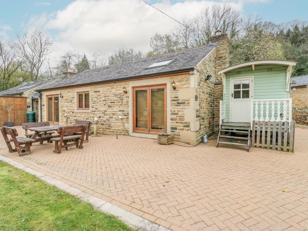 ein Cottage aus Stein mit einem Picknicktisch und einer Bank in der Unterkunft 4 Pheasant Lane in Sheffield