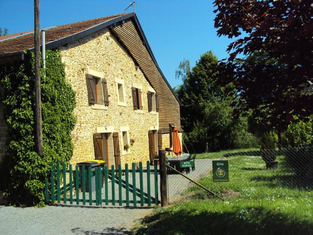 ein kleines Steinhaus mit einem grünen Zaun in der Unterkunft Chez laure 