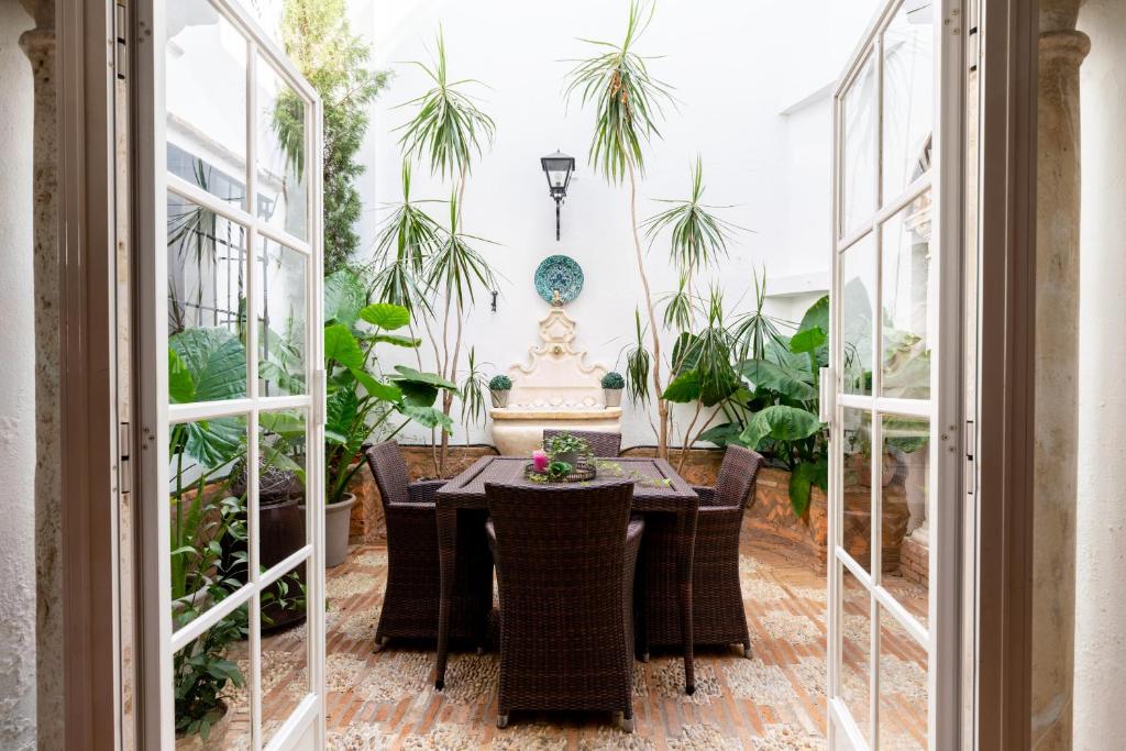 a dining room with a table and some plants at Ático con encanto en Sierpes in Seville