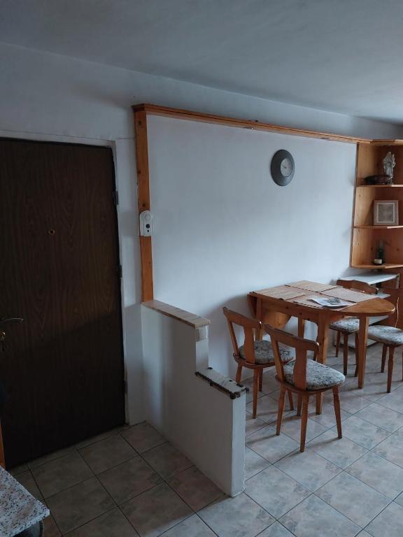 クルジュ・ナポカにあるApartamentのテーブルと椅子、ドアが備わる部屋