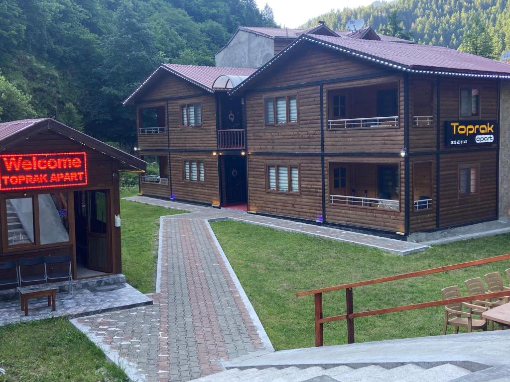 a large wooden building with a sign on it at New toprak suite in Uzungöl