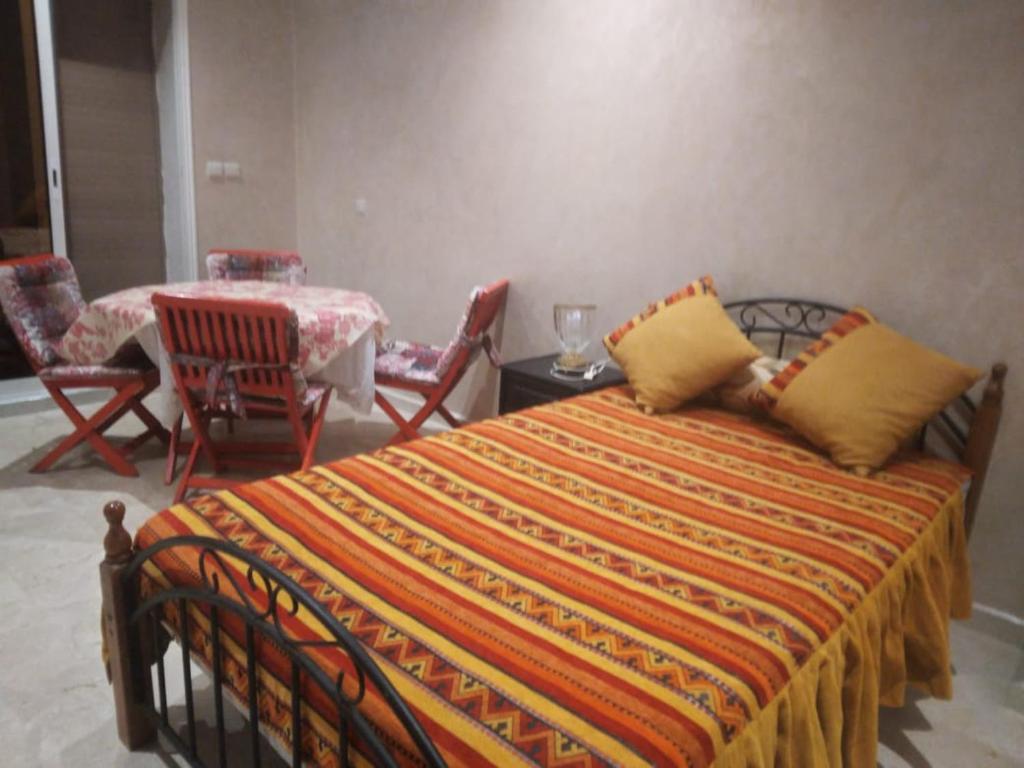 - une chambre avec un lit, une table et des chaises dans l'établissement Golden Beach, à Dar Hamida