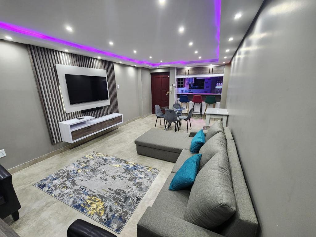 a living room with a couch and a tv at 1901 on Hightide in Amanzimtoti